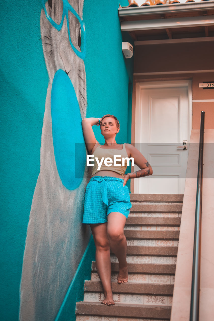 Woman standing by wall