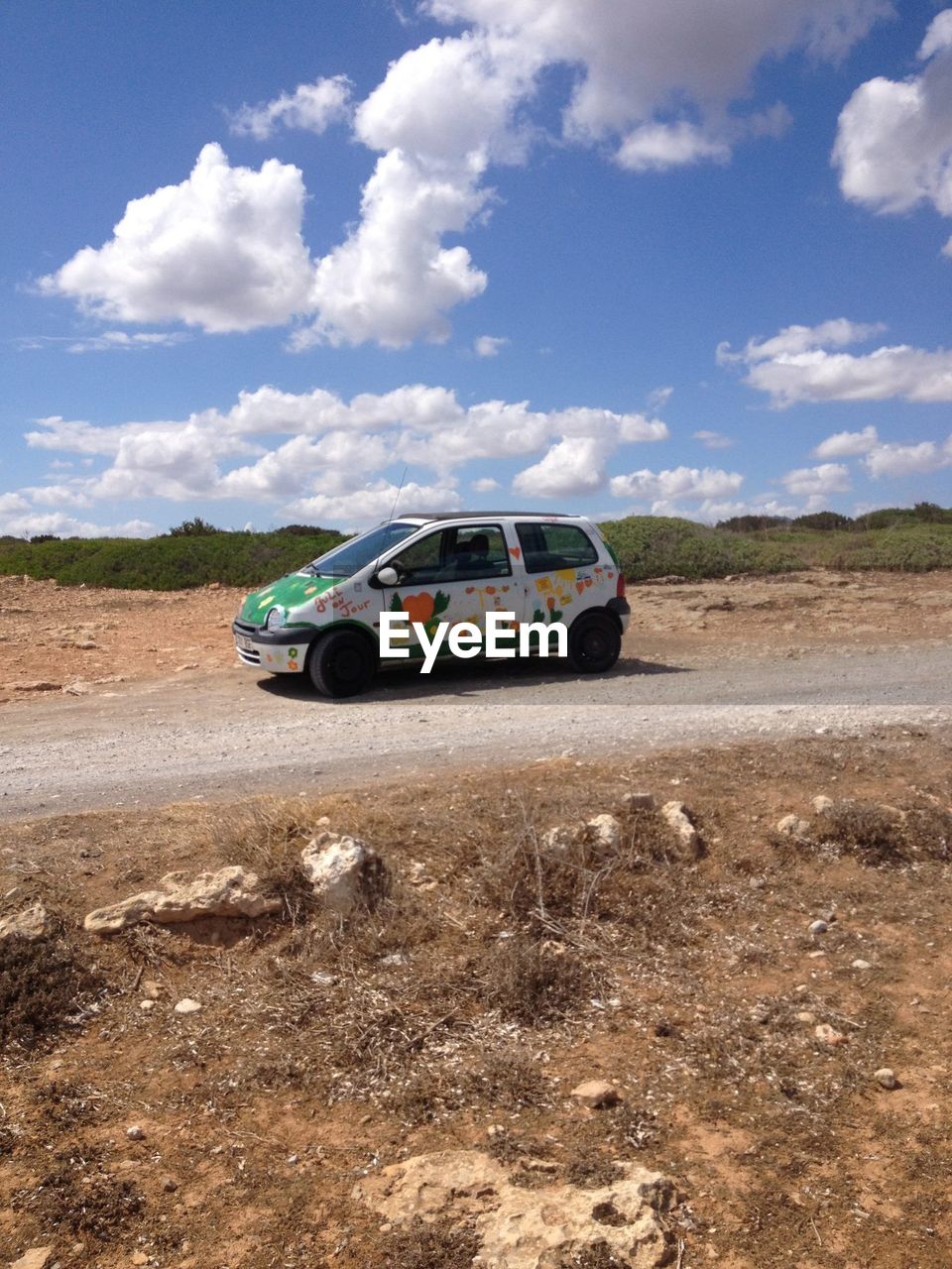 CAR ON DIRT ROAD ON FIELD