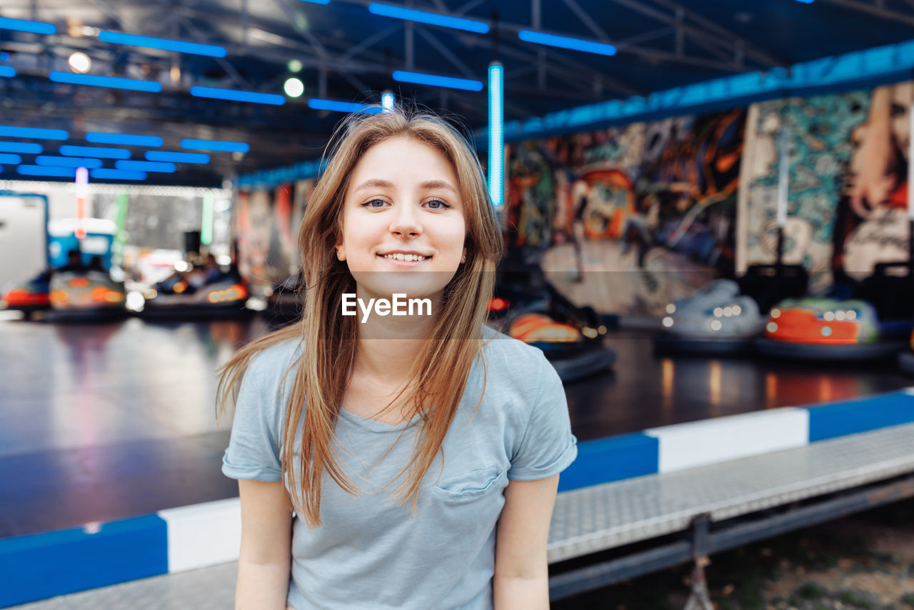 Happy young gen z woman in an amusement park, smiling