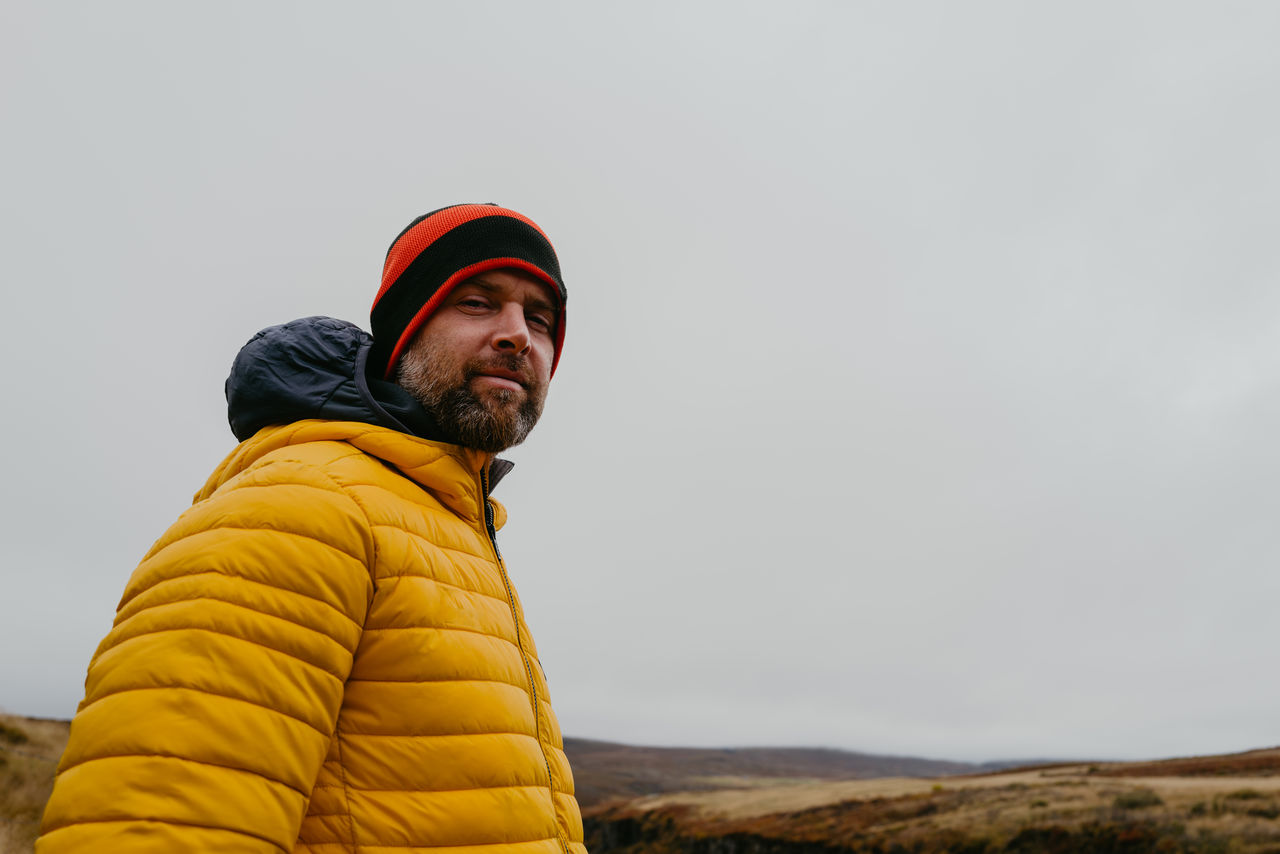 Man in yellow jacket in iceland looking at the camera