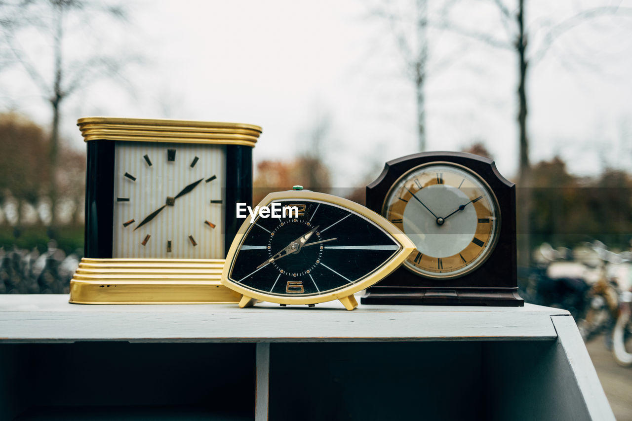 clock, time, alarm clock, no people, clock face, focus on foreground, day, nature, outdoors, furniture, yellow, watch, tree, accuracy