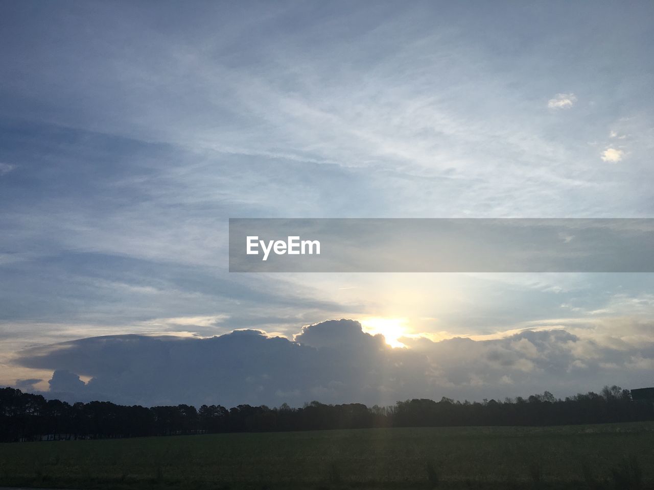 Scenic view of grassy field against cloudy sky