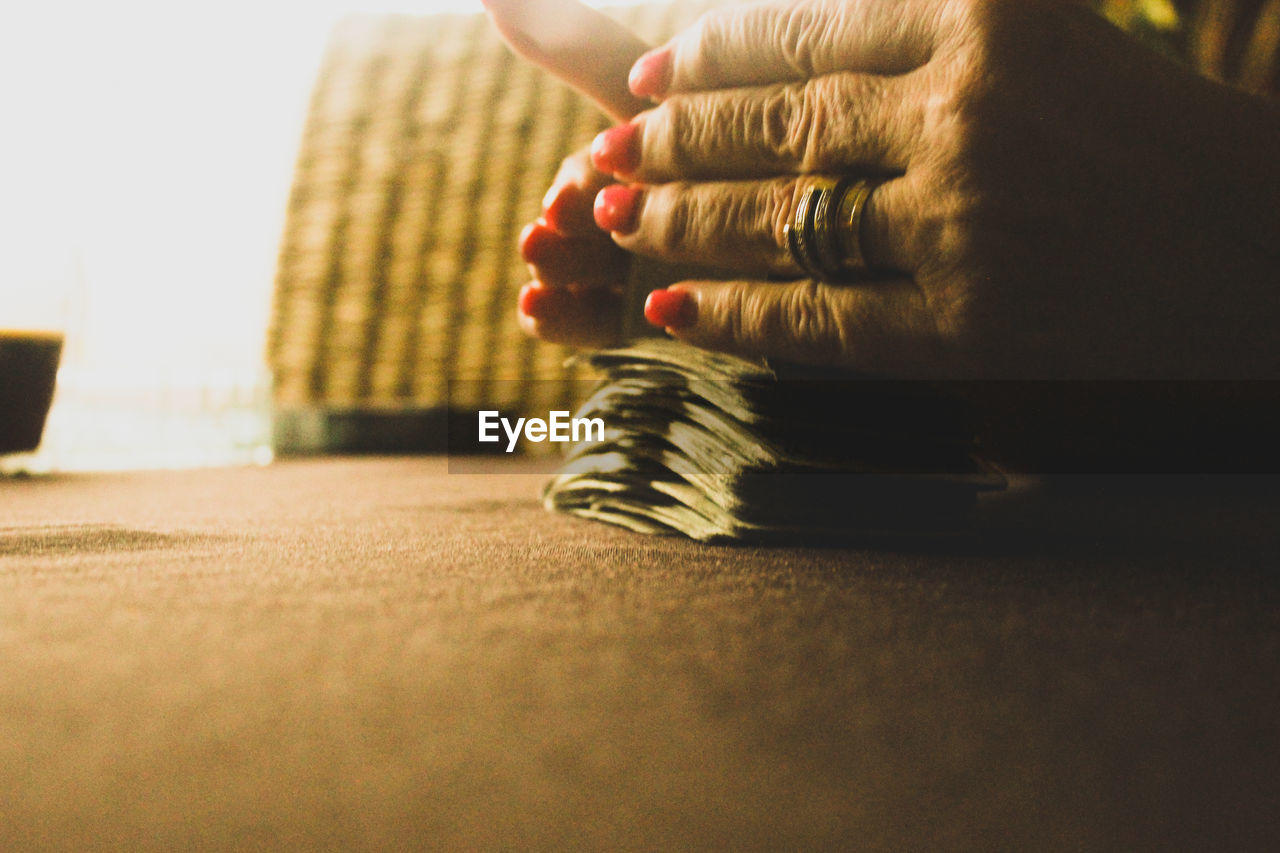 Cropped hands of woman shuffling cards on table