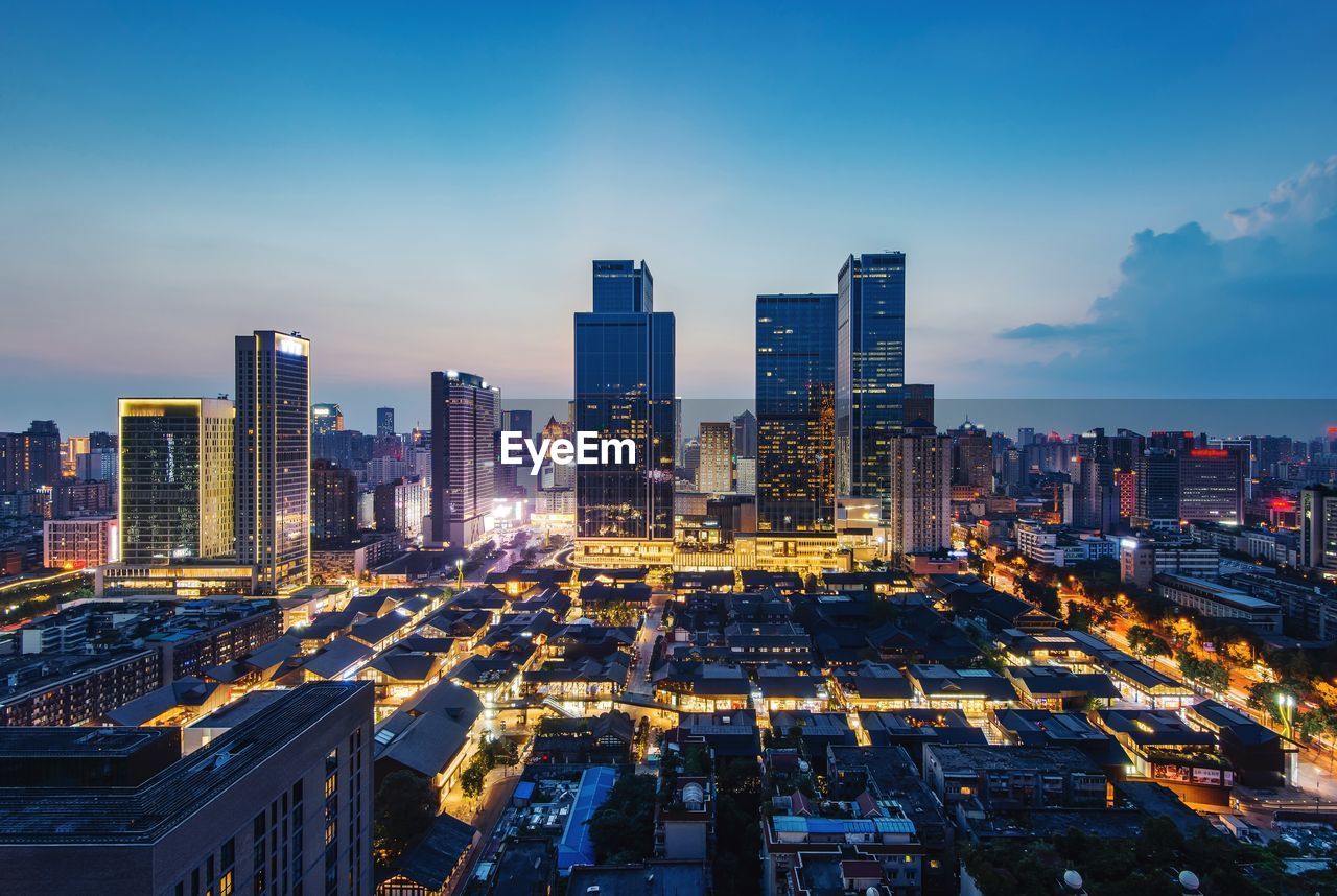 High angle view of illuminated buildings in city against sky at dusk