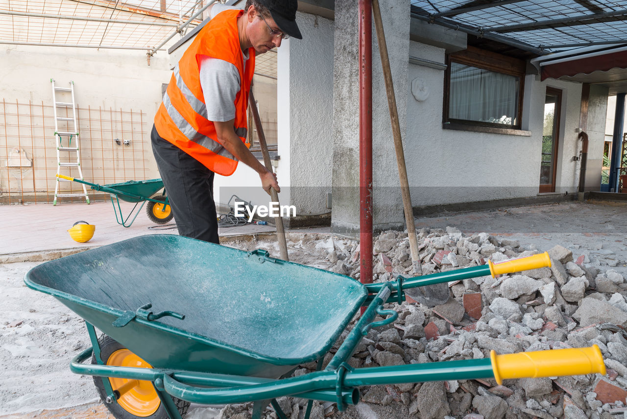 MAN WORKING WITH UMBRELLA STANDING AT STADIUM