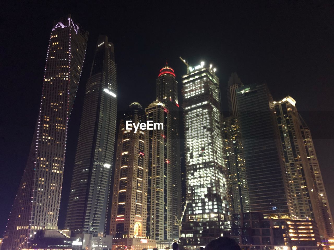 Low angle view of illuminated buildings against sky at night