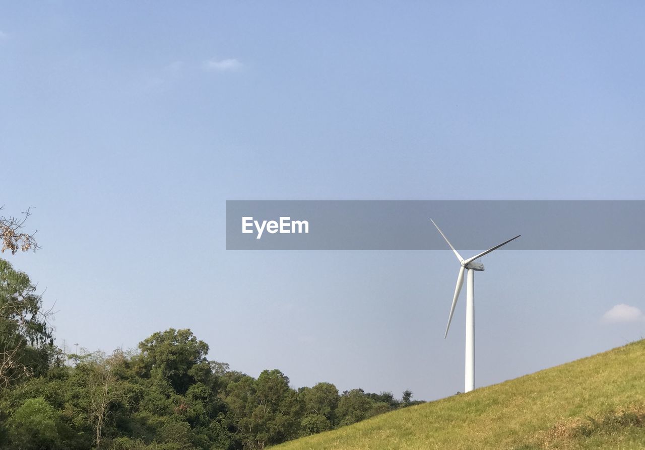 LOW ANGLE VIEW OF WIND TURBINES ON FIELD