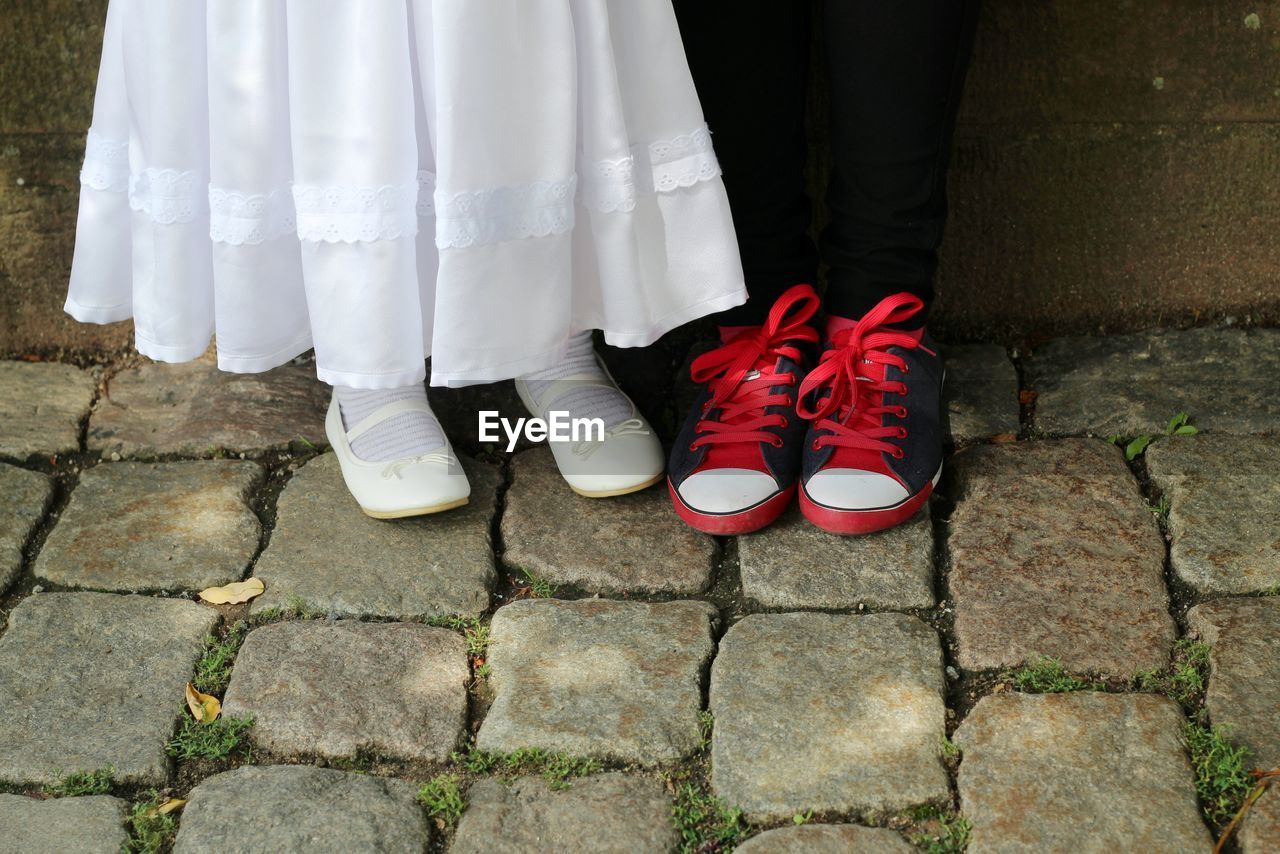 LOW SECTION OF PEOPLE STANDING ON COBBLESTONE