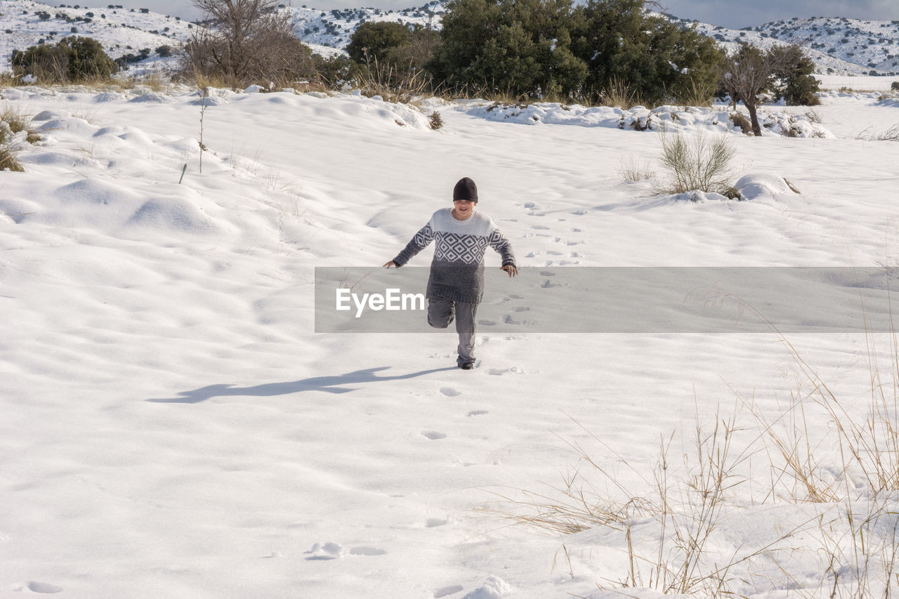 winter, snow, one person, cold temperature, full length, nature, leisure activity, land, child, childhood, men, day, environment, plant, white, landscape, lifestyles, tree, vacation, rear view, holiday, skiing, footwear, trip, clothing, beauty in nature, outdoors, piste, warm clothing, motion, scenics - nature, walking, mountain, winter sports, fun, sports, sunlight, enjoyment, travel, adult, sky