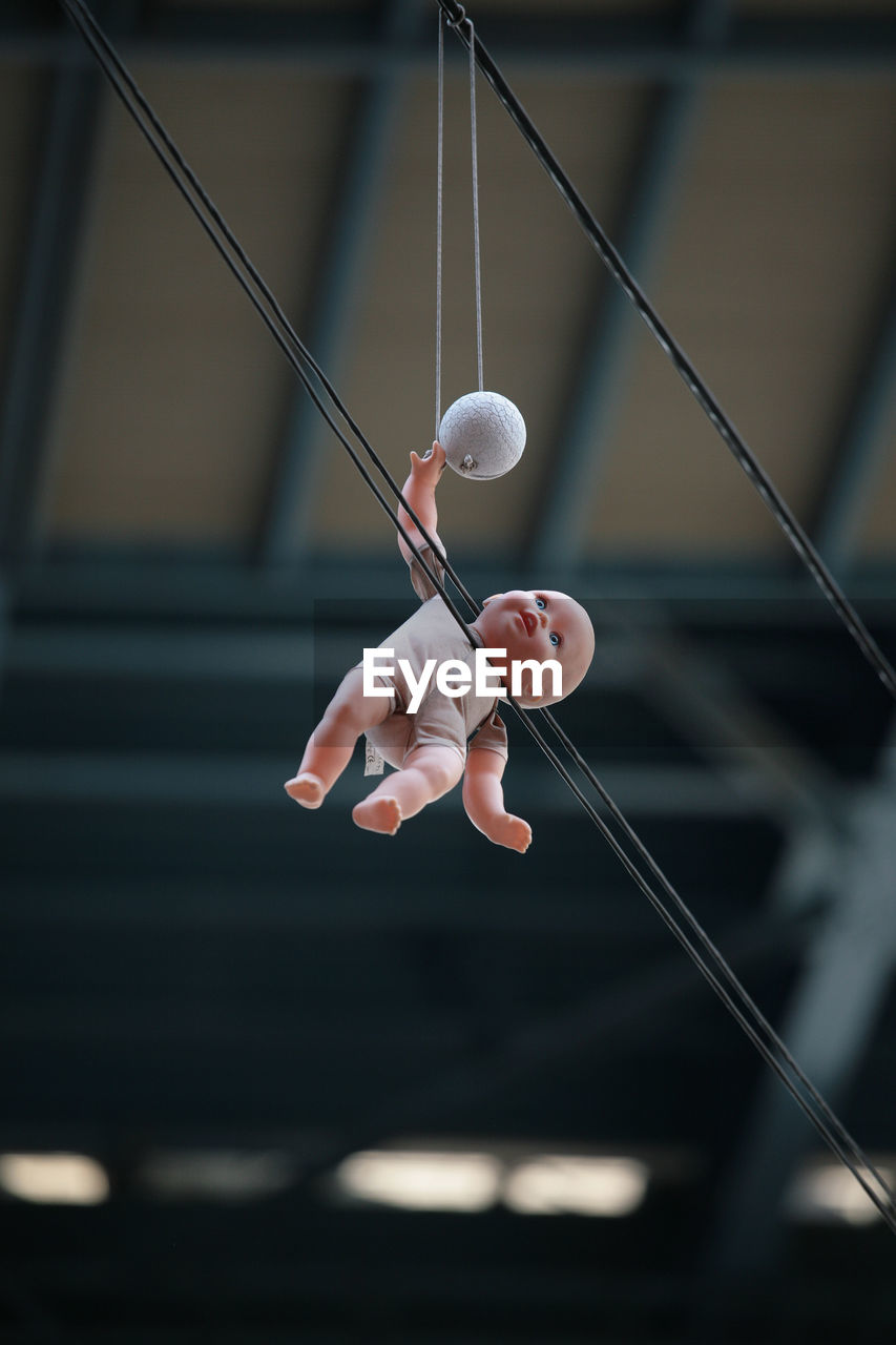 Low angle view of toy hanging on cable