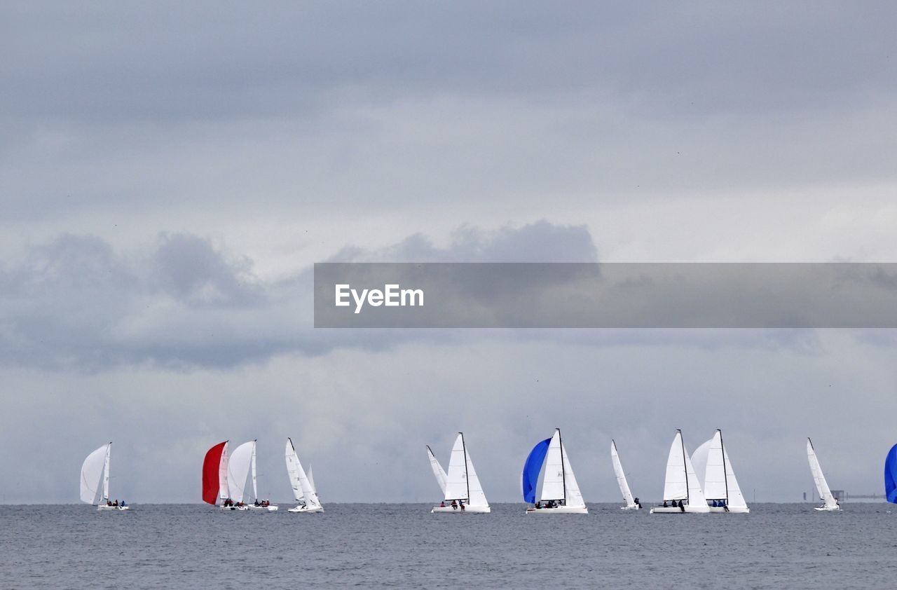 SAILBOAT SAILING ON SEA AGAINST SKY