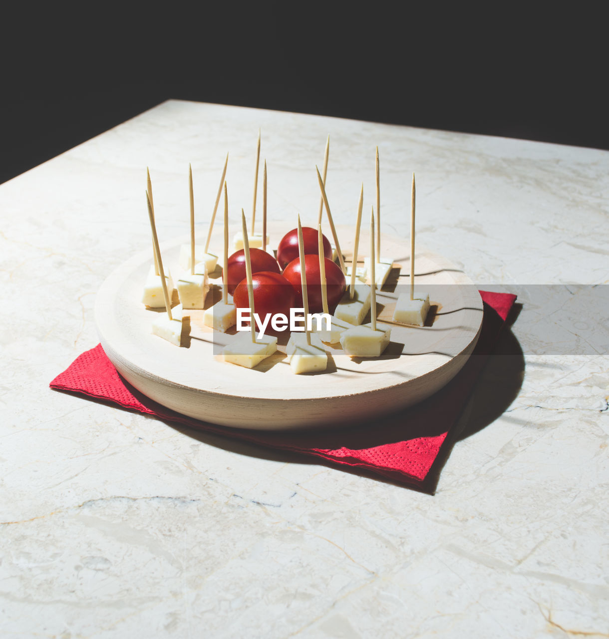 High angle view of cheese and cherry tomatoes in plate on table