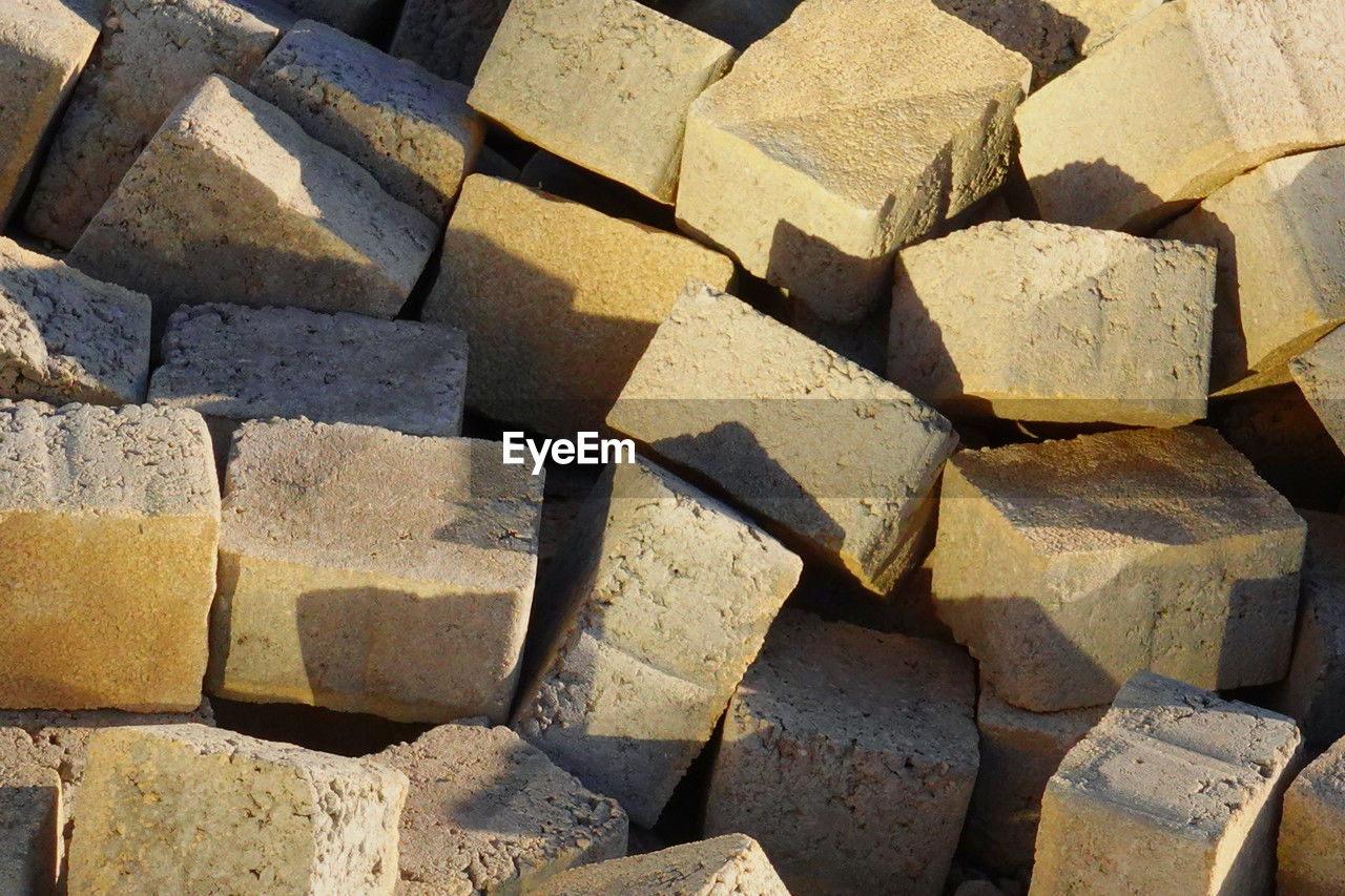 full frame, backgrounds, wall, large group of objects, brick, stone wall, abundance, wood, soil, no people, pattern, rock, sunlight, day, nature, shape, textured, block, repetition, outdoors, brickwork, floor, arrangement, close-up, high angle view, road surface