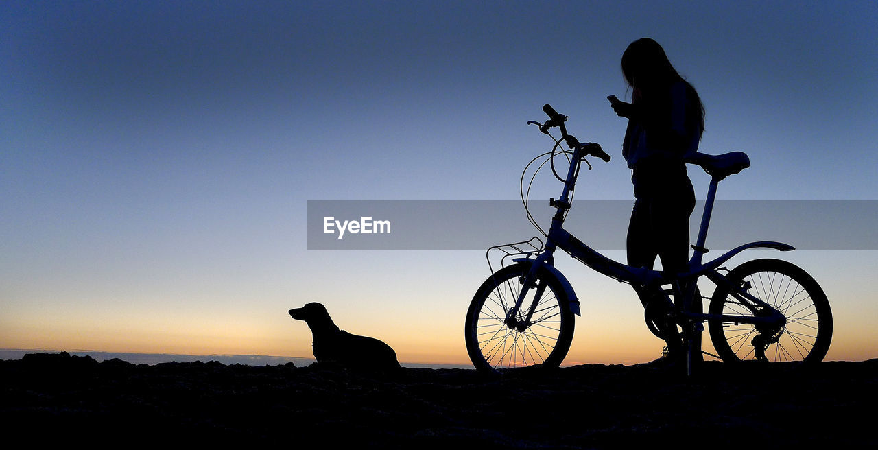 SILHOUETTE MAN AGAINST BICYCLE DURING SUNSET
