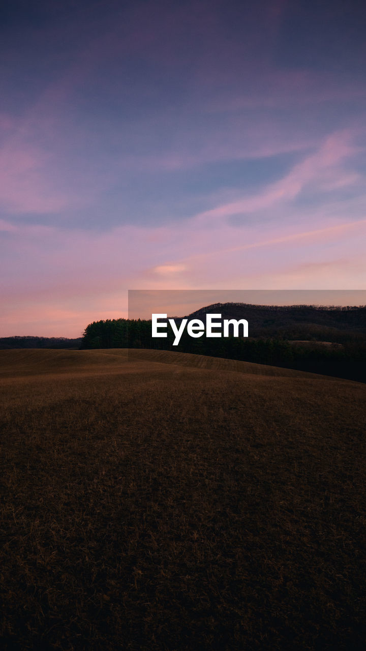 SCENIC VIEW OF AGRICULTURAL FIELD AGAINST SKY DURING SUNSET