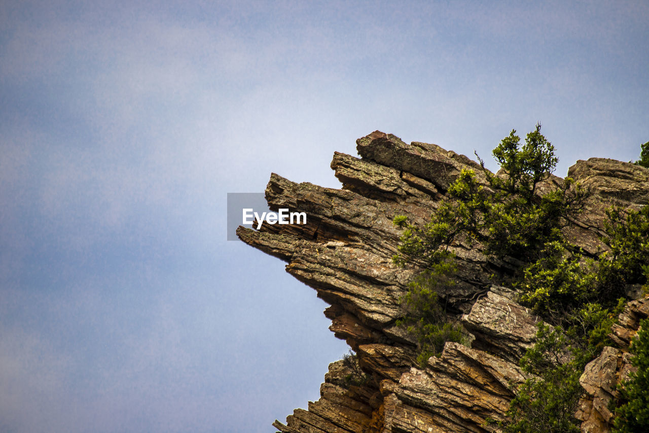 LOW ANGLE VIEW OF ROCKS AGAINST CLEAR BLUE SKY