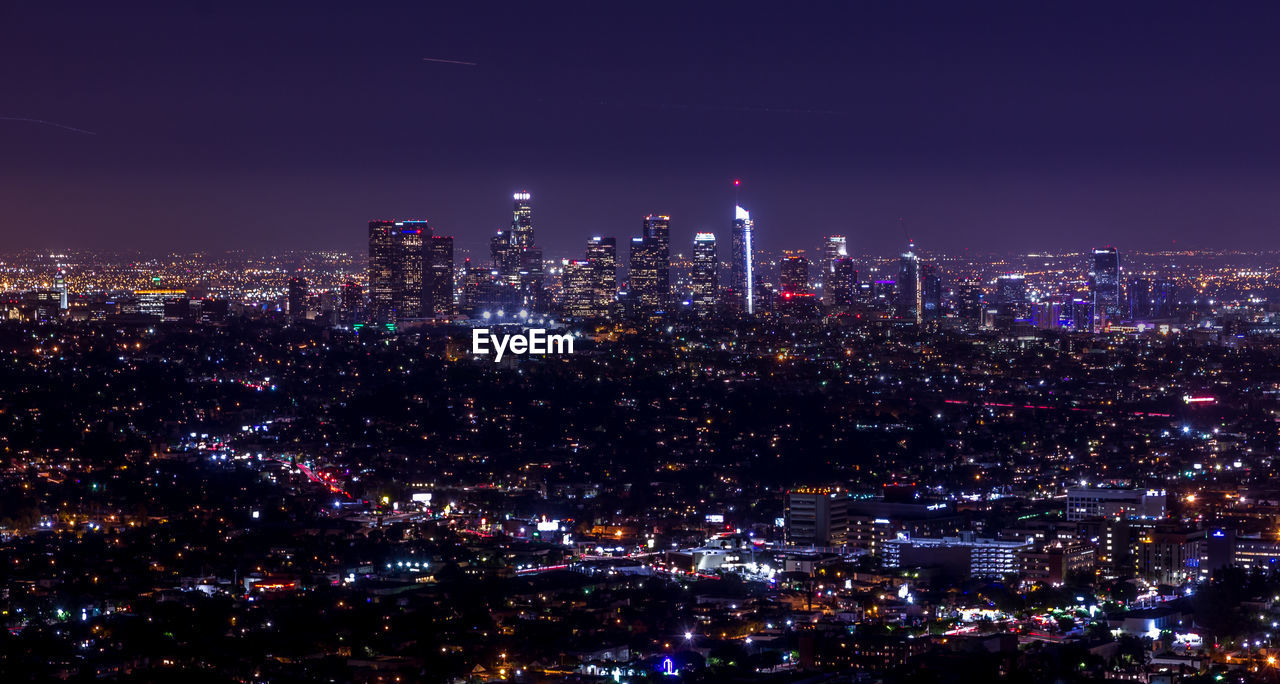 Illuminated city against sky at night