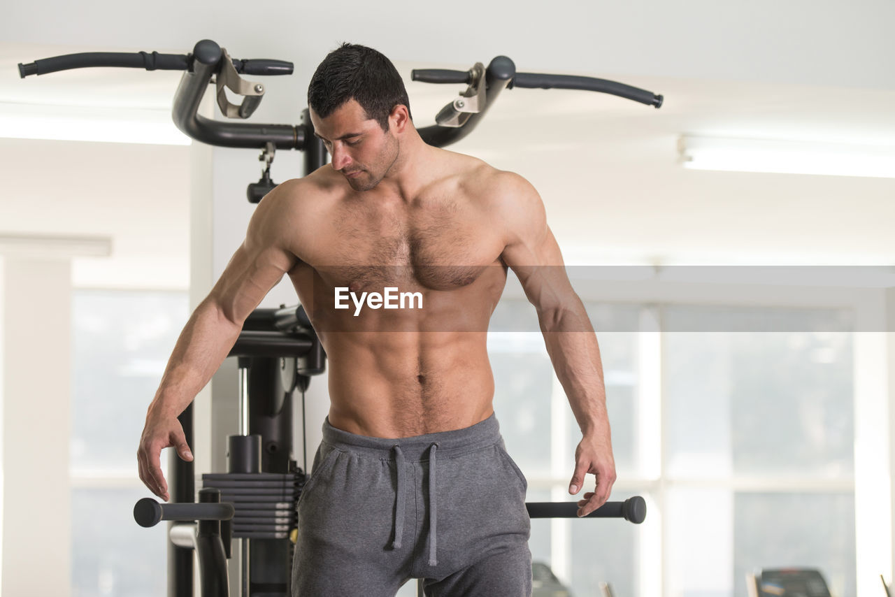 Shirtless muscular man exercising in gym