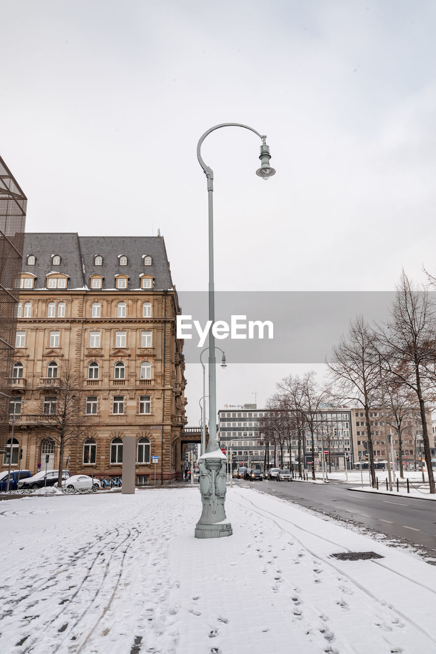 STREET COVERED WITH SNOW AGAINST SKY