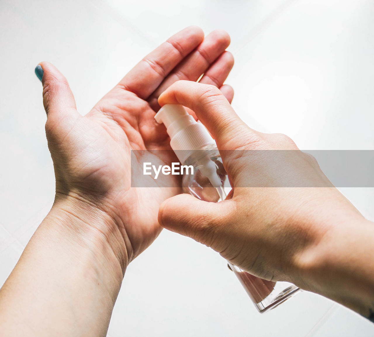 Female hands applying hand sanitizer gel