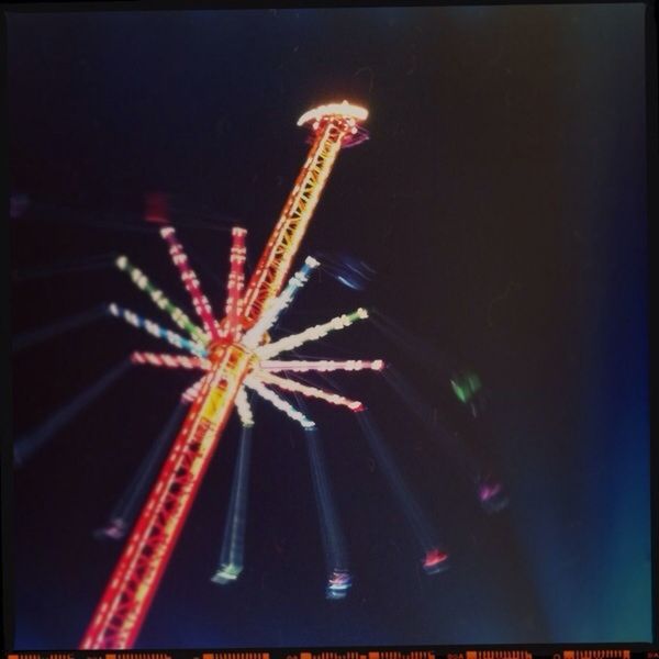 LOW ANGLE VIEW OF ILLUMINATED FERRIS WHEEL AT NIGHT