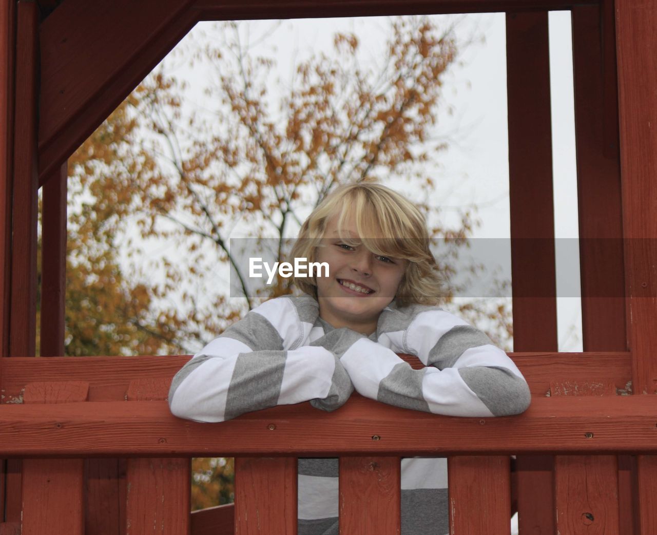 Portrait of blonde boy leaning on railing