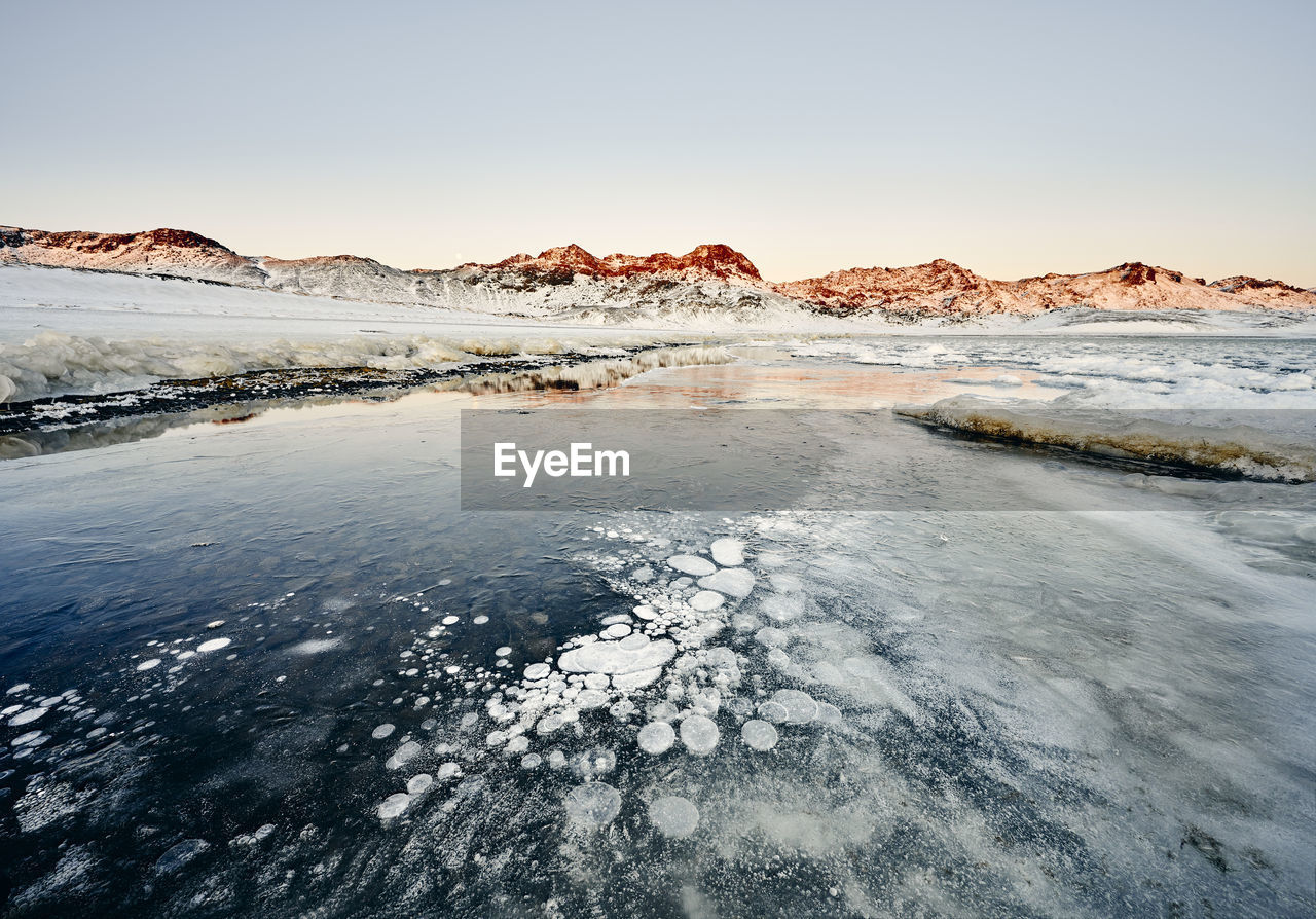 Coastline with ice and snow against rocks in winter