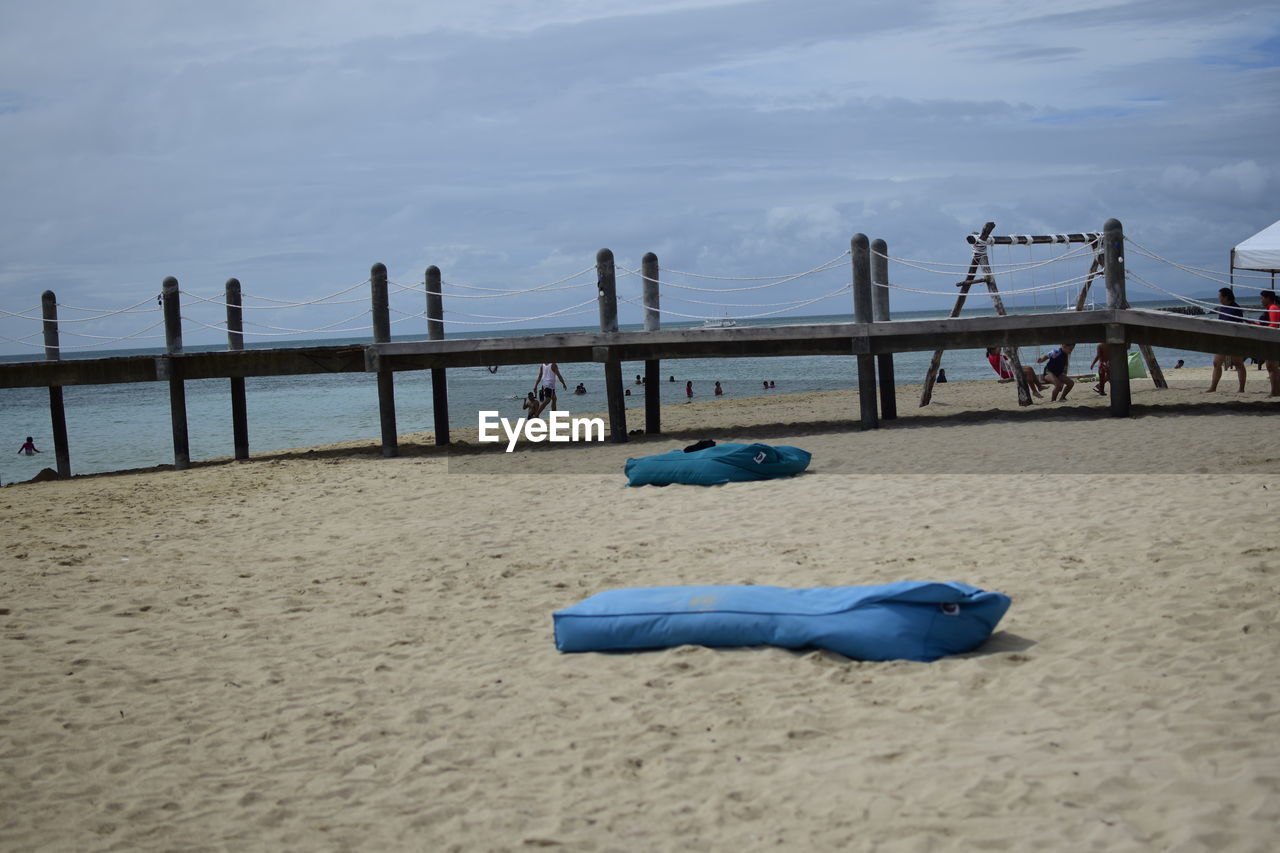 Deck chairs on beach against blue sky