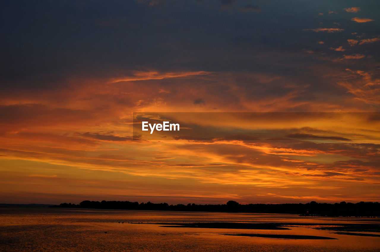 SCENIC VIEW OF DRAMATIC SKY OVER SILHOUETTE LANDSCAPE DURING SUNSET