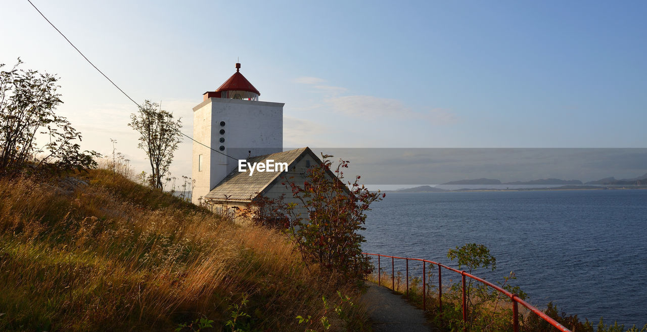 Tranquil landscape with a red and white lighthouse in norway