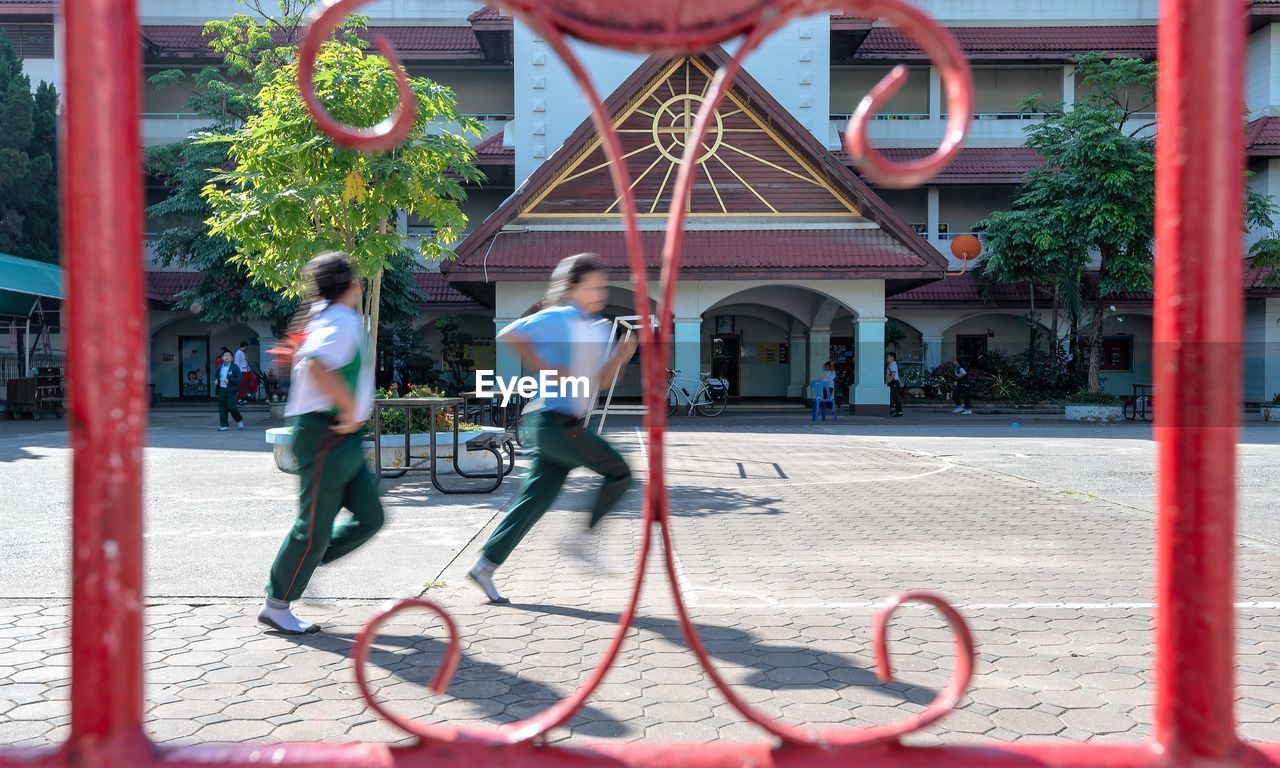 SIDE VIEW OF MEN WALKING ON STREET