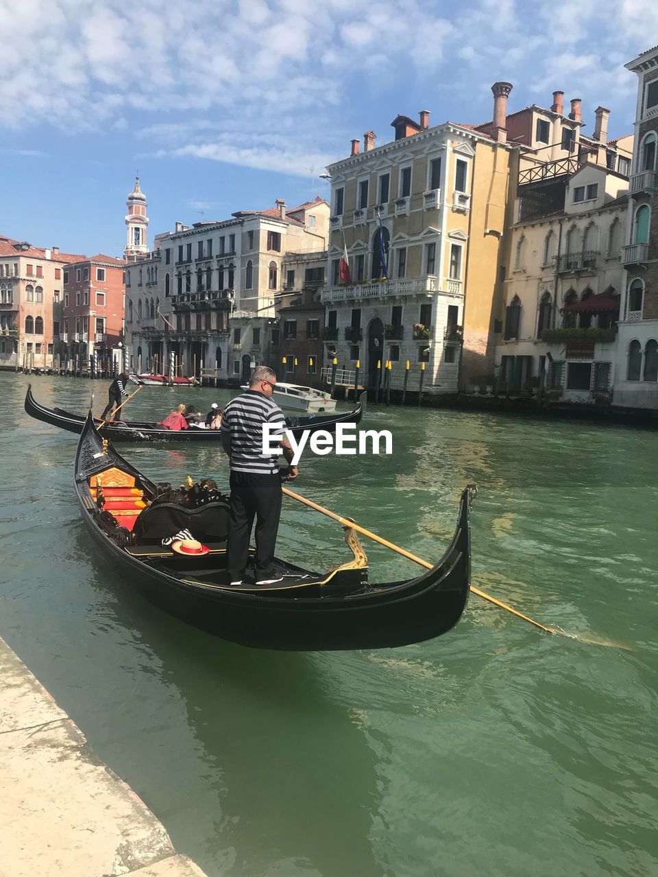 MAN IN CANAL AMIDST CITY