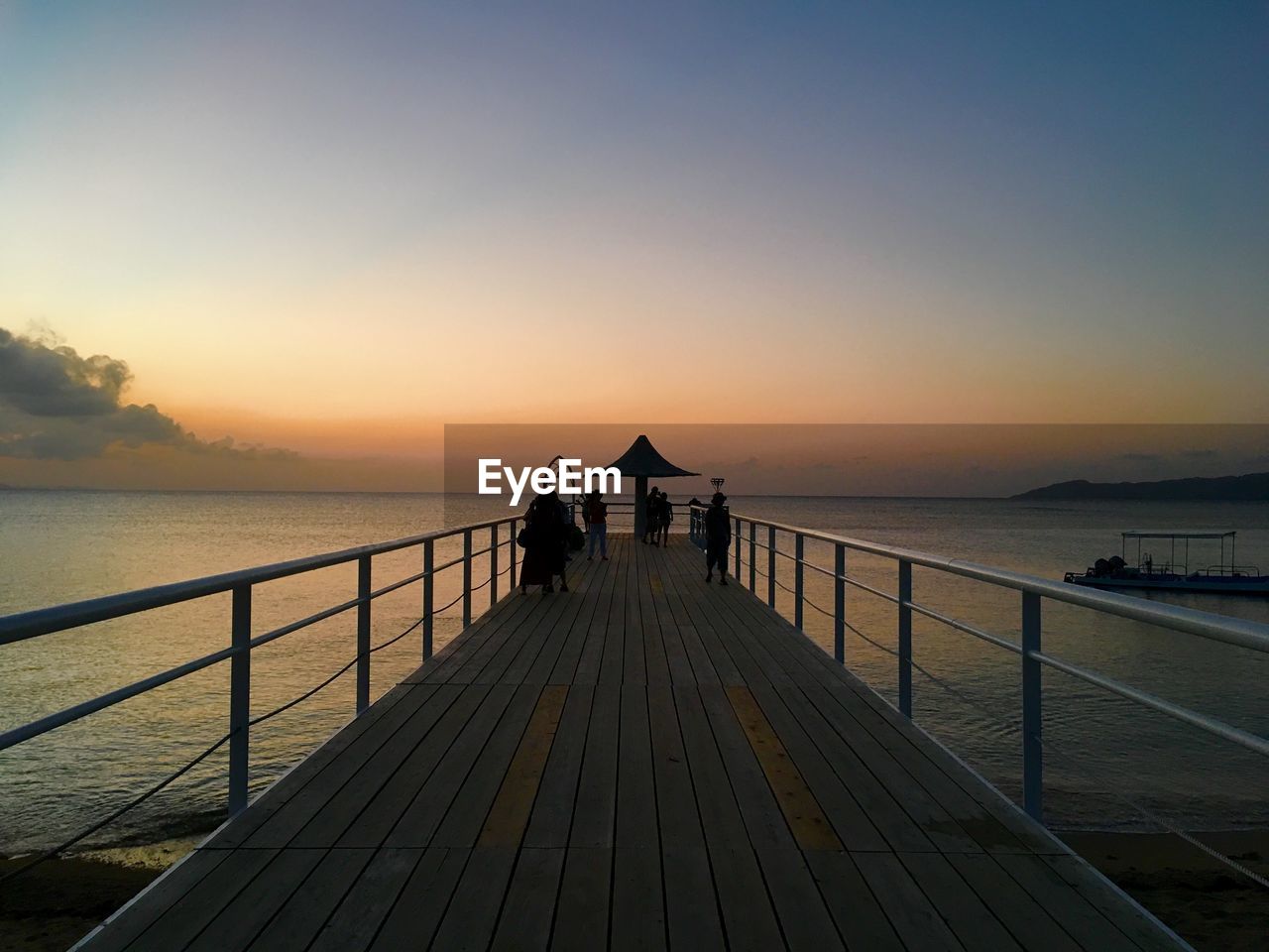 Pier over sea against sky during sunset