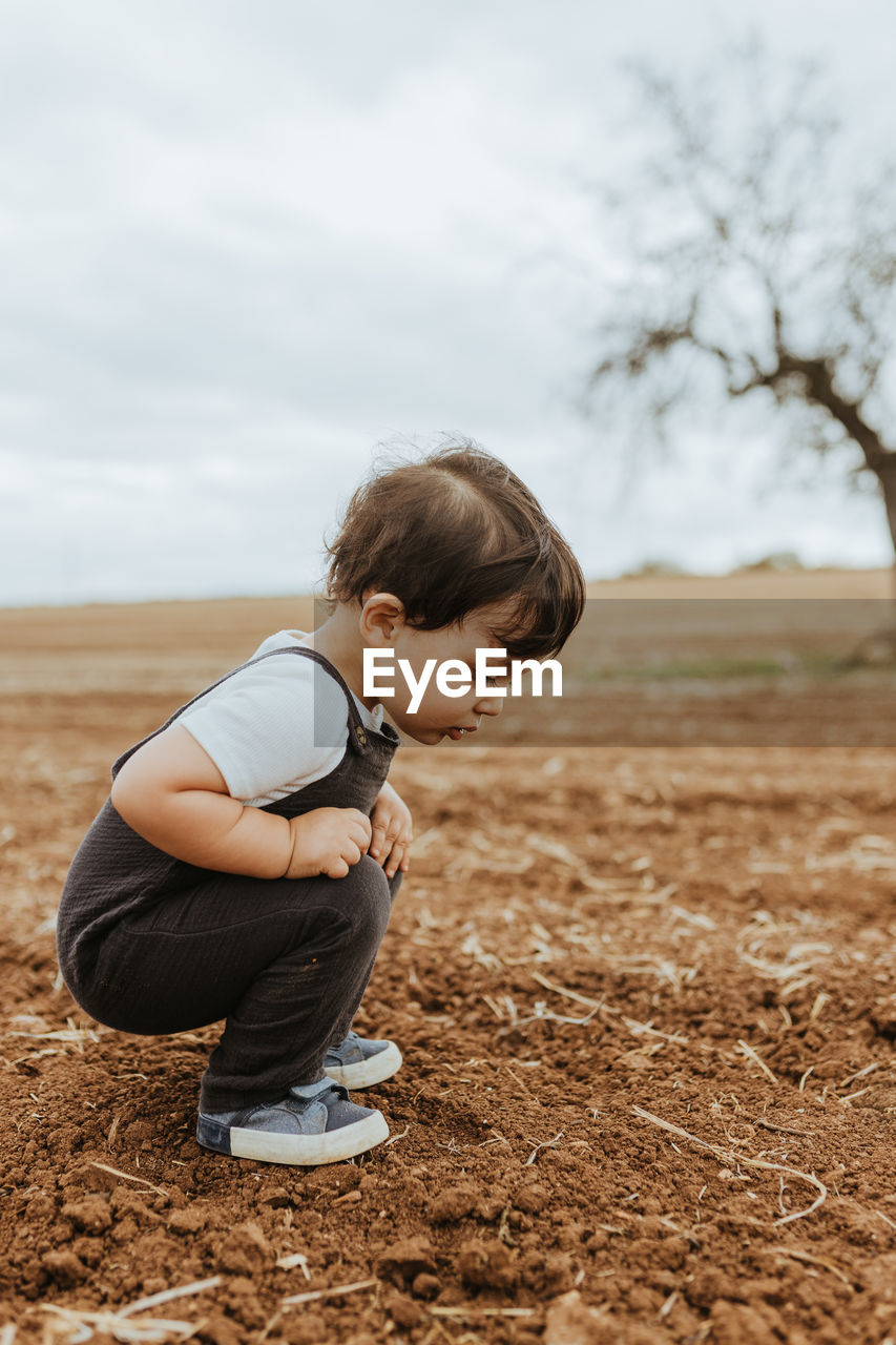 Portrait of child looking at ants in the fields