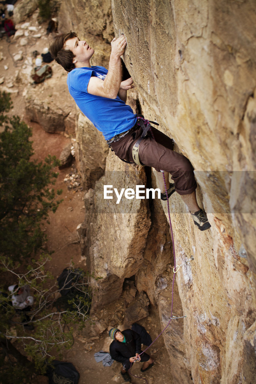 Side view of man climbing mountain