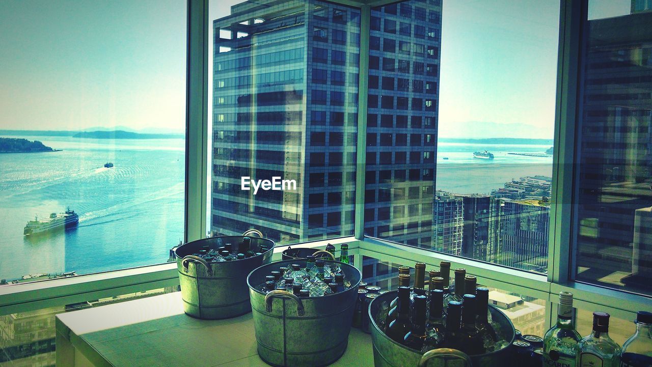 Chilled wine bottles in buckets against skyscraper