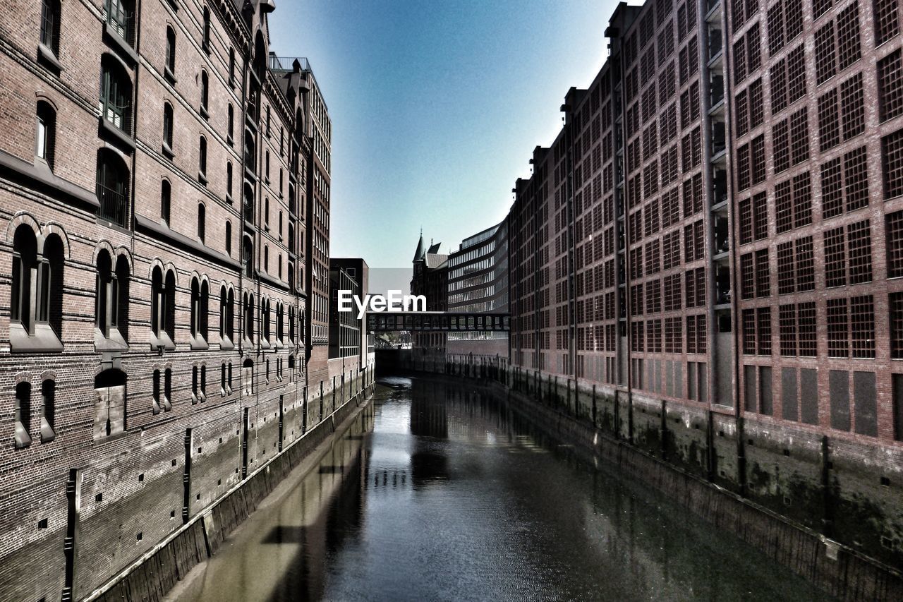 CANAL AMIDST BUILDINGS AGAINST SKY