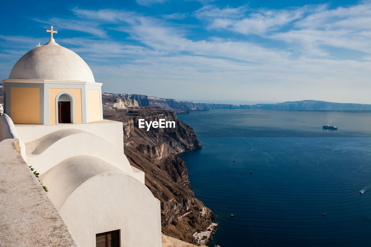 The aegean sea and the catholic church of st. stylianos in the city of fira in santorini island