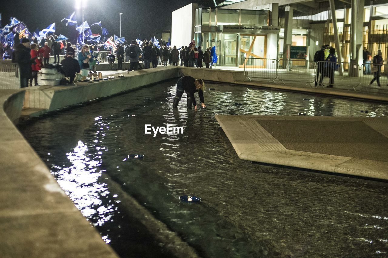 GROUP OF PEOPLE WALKING IN CITY AT NIGHT