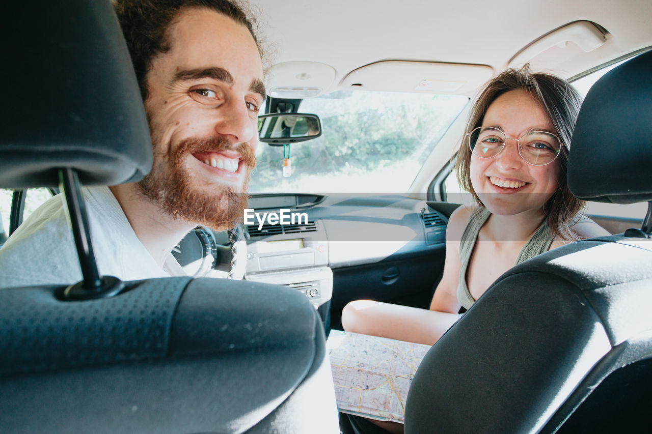 Portrait of happy couple sitting in car