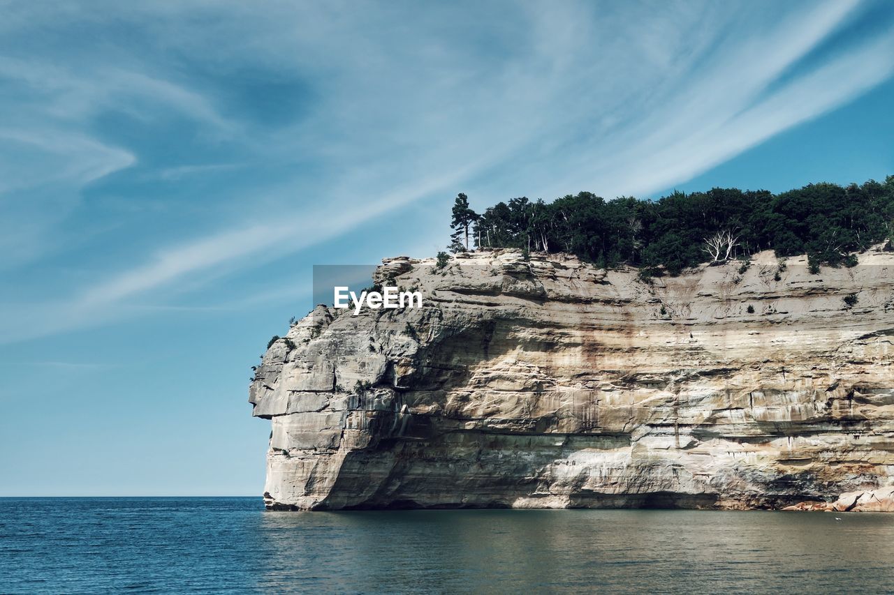 Rock formations by sea against sky