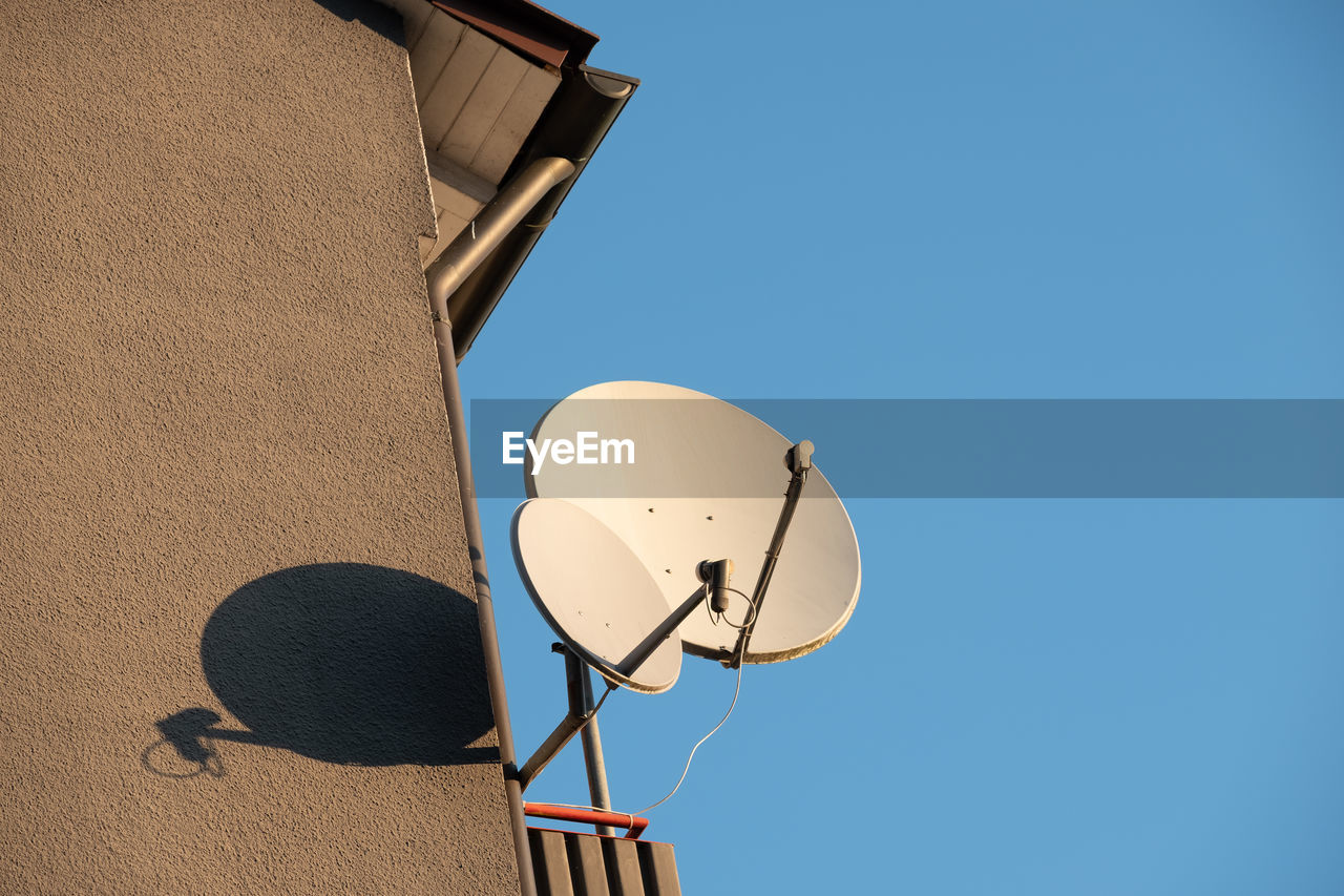 Low angle view of satellite dish  against clear blue sky