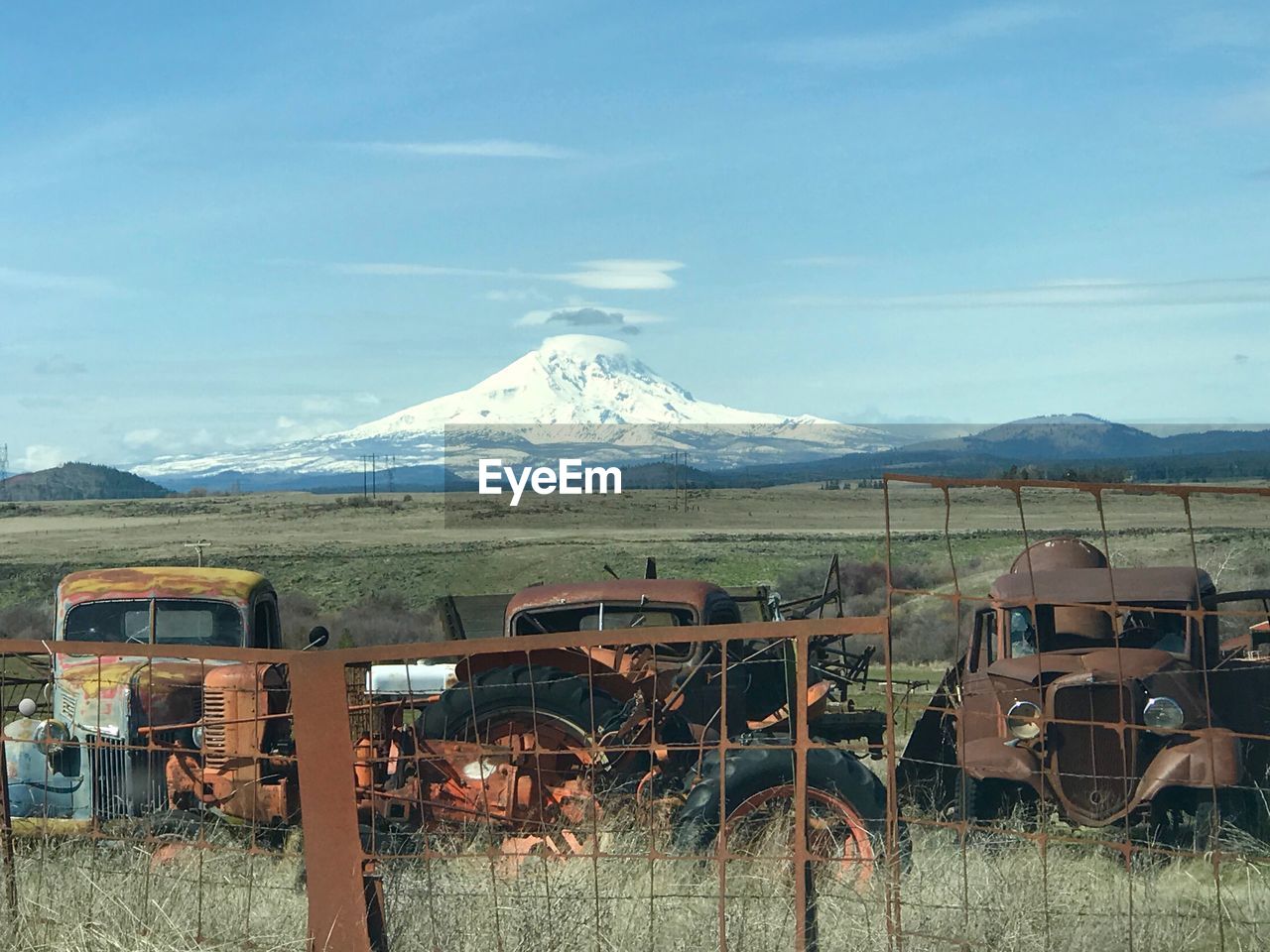 ABANDONED VEHICLE ON FIELD AGAINST SKY