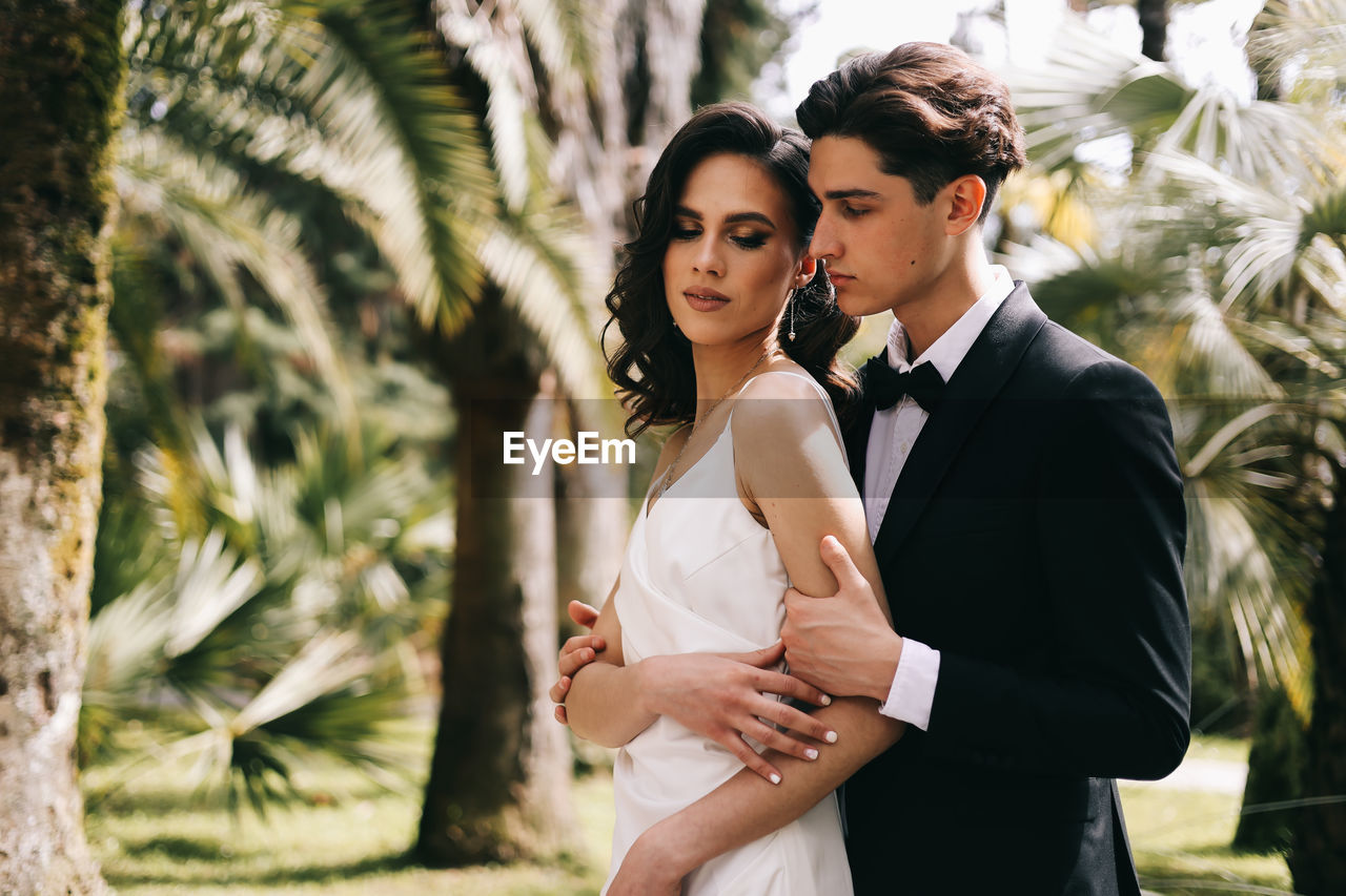 A beautiful couple in love, bride and groom in wedding clothes, walk and pose in the park in nature
