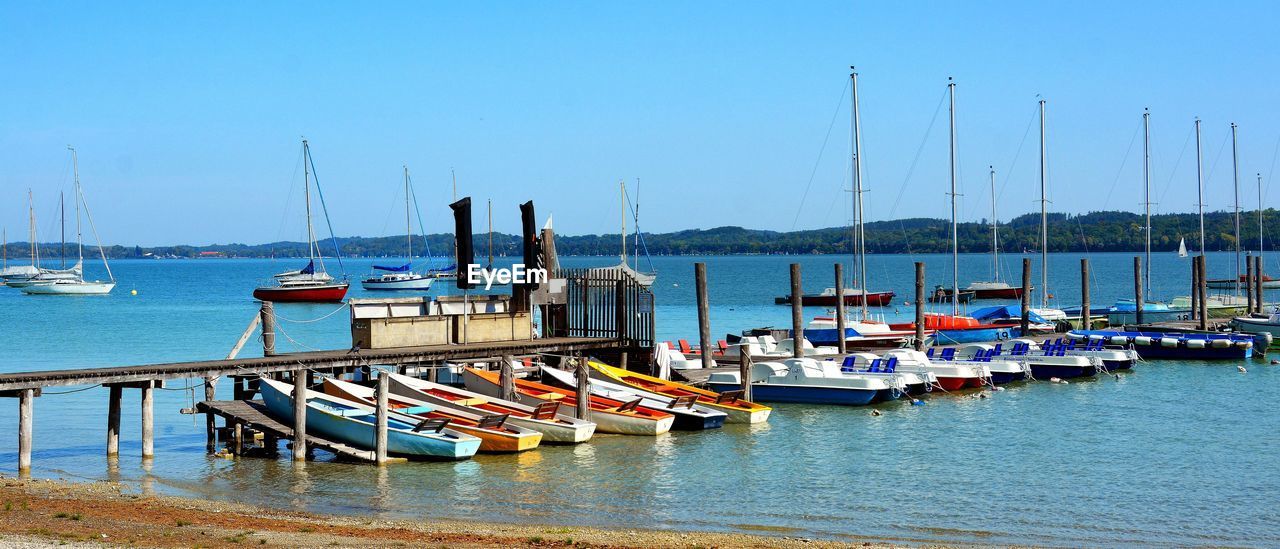 Sailboats moored in harbor