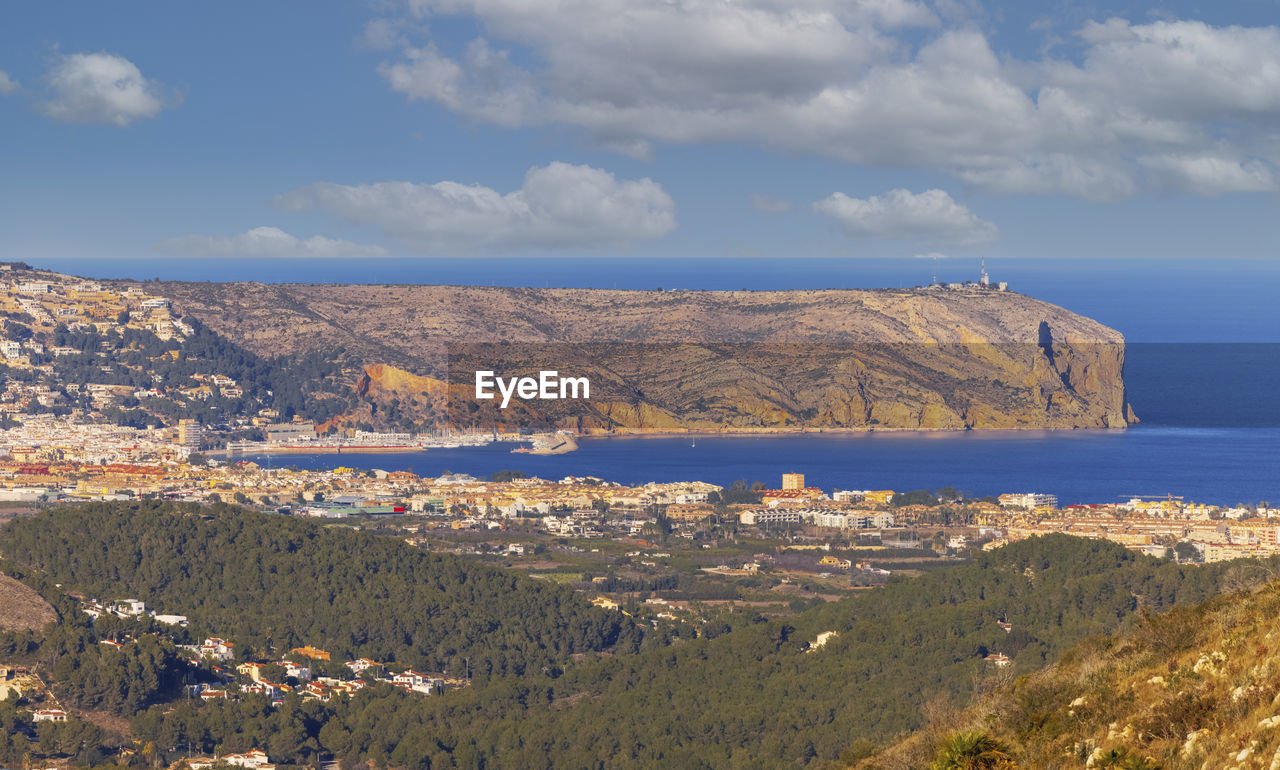 Scenic view of sea and cityscape against sky