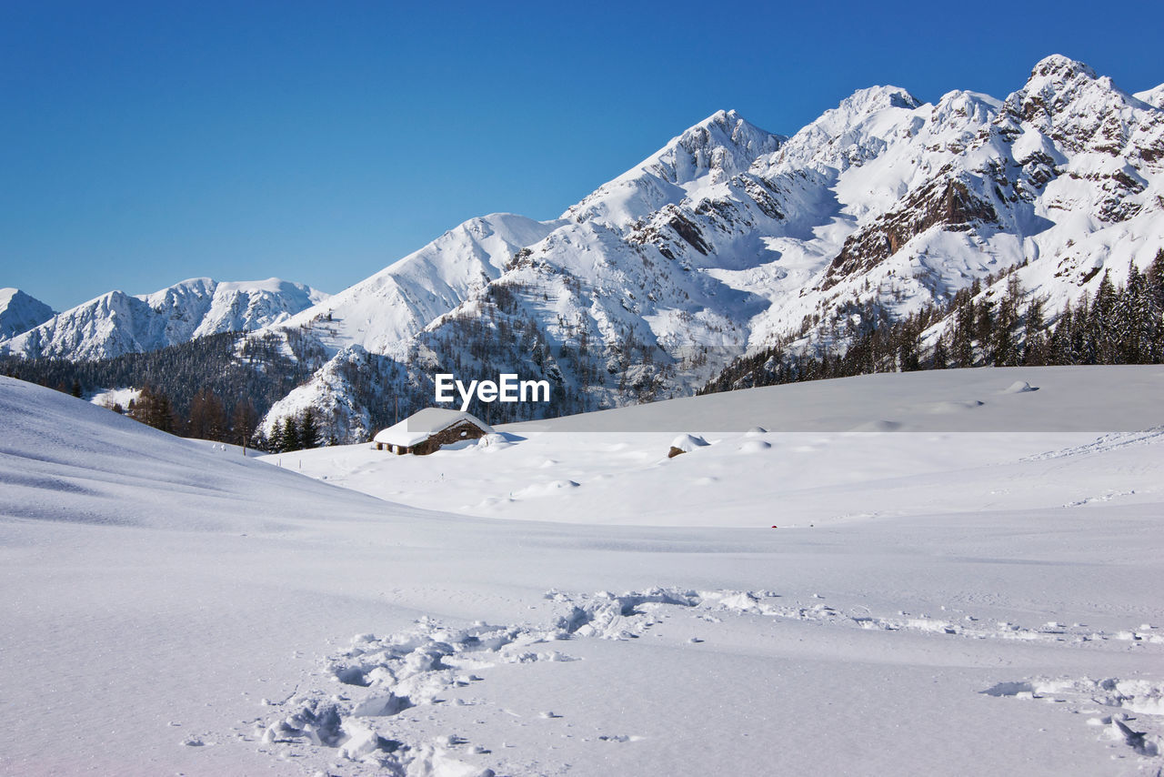 Scenic view of snowcapped mountains against clear blue sky