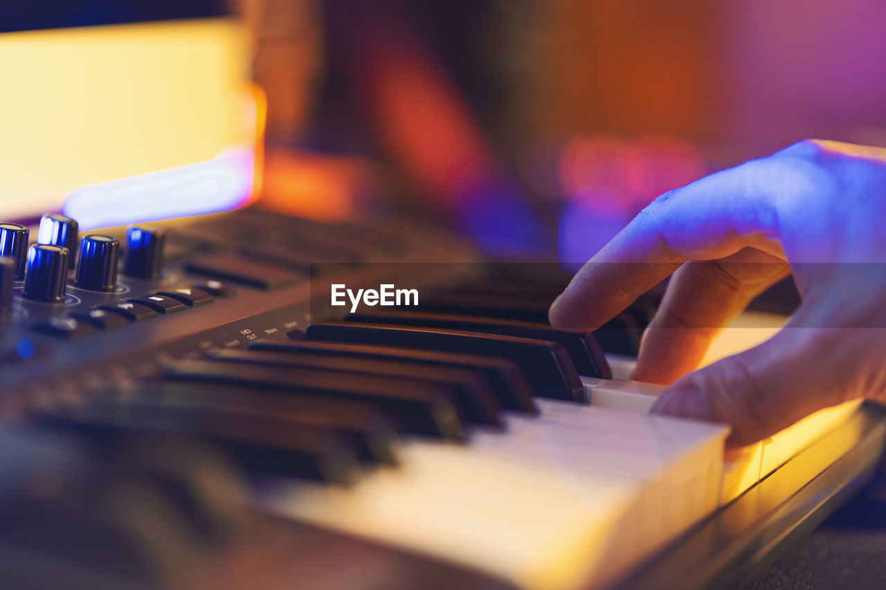 Close-up of person hand playing piano