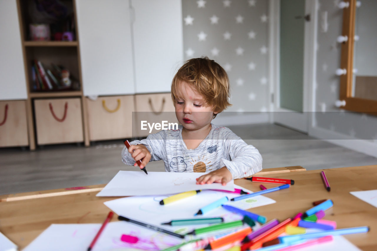 Little boy drawing with felt-tip pens