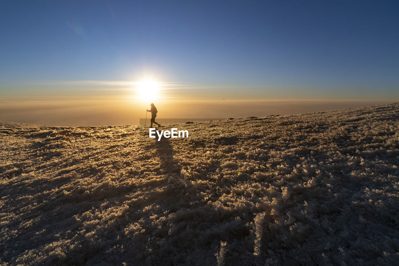 One person walking through ayoloco glacier at sunset at iztaccihuatl
